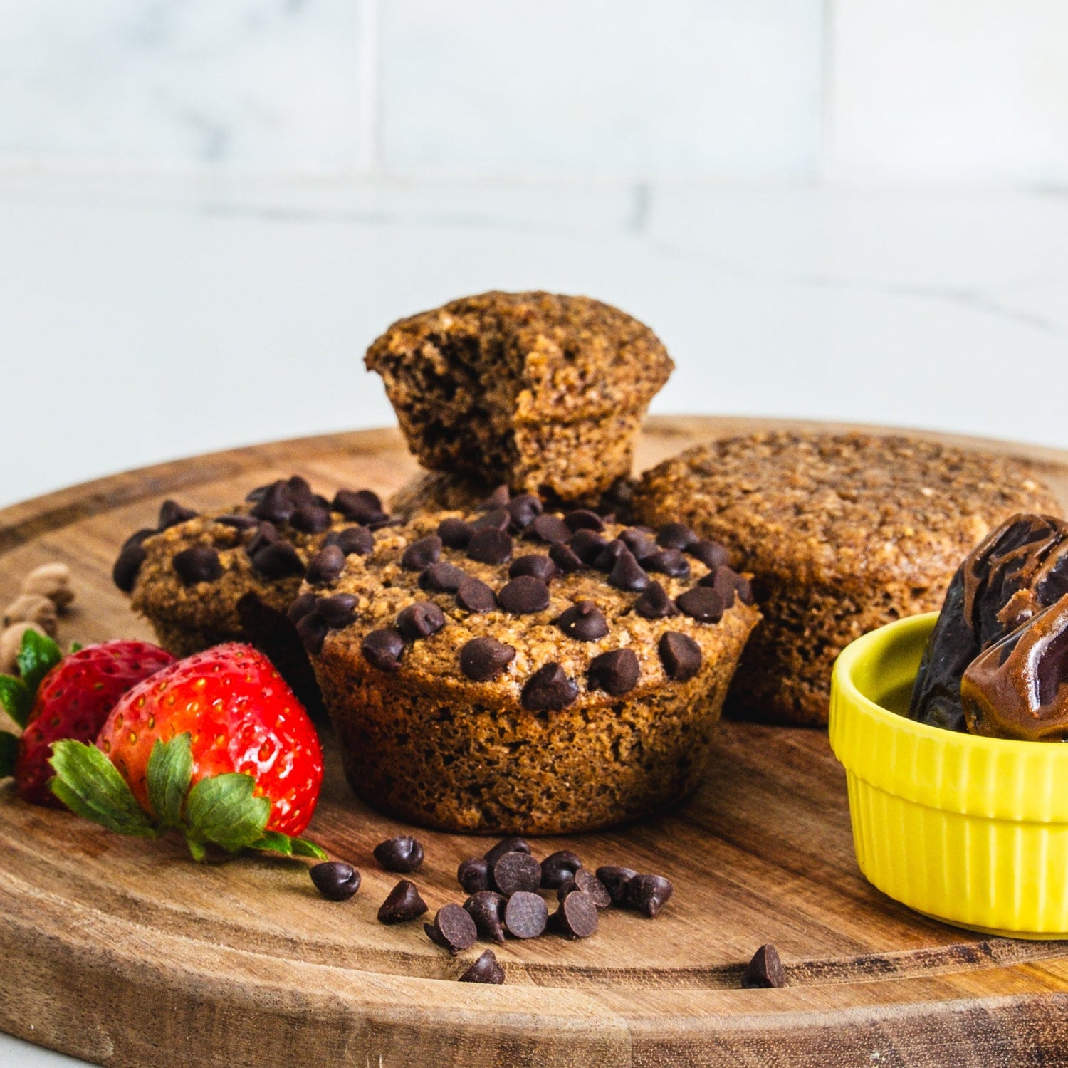 chickpea chocolate chip muffins on.a cutting board with strawberries 